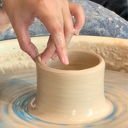 Pulling up the sides of a pot on the wheel.