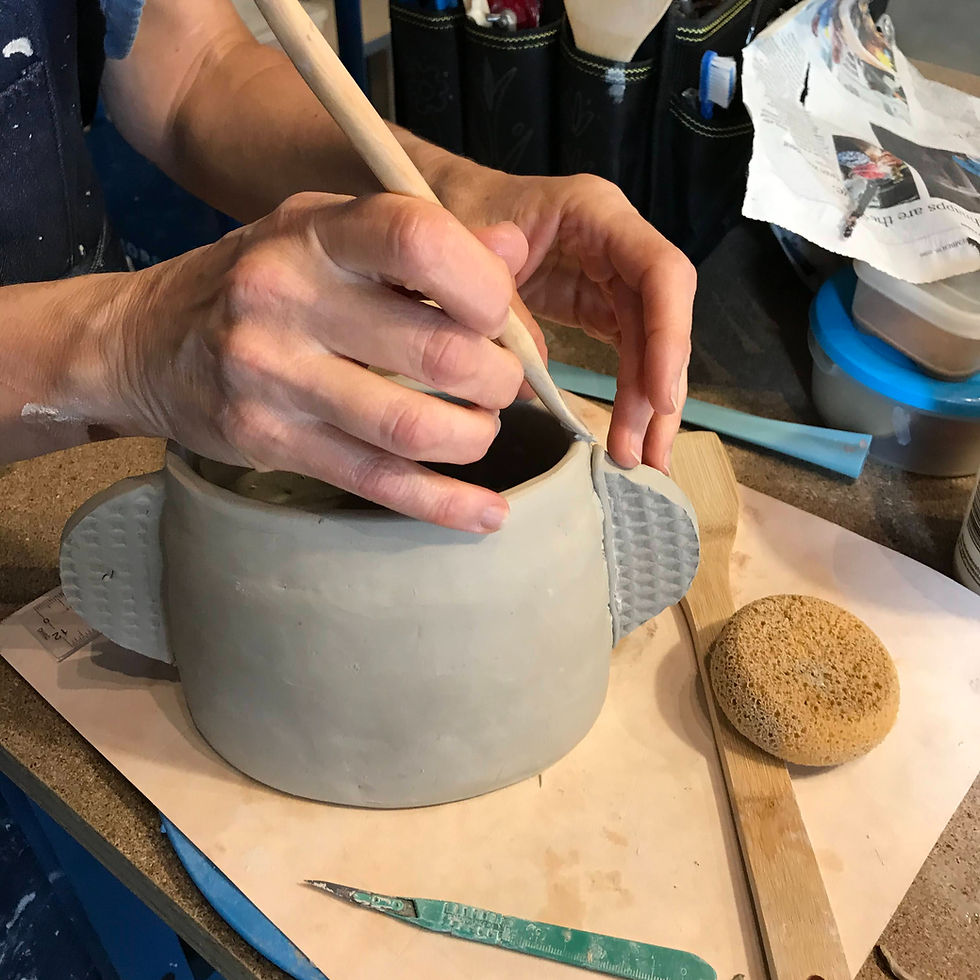 Attaching textured handles to a handbuild mug.