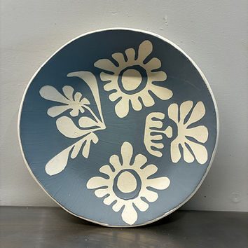 Handmade ceramic wall pieces featuring floral surface decoration and carved details.