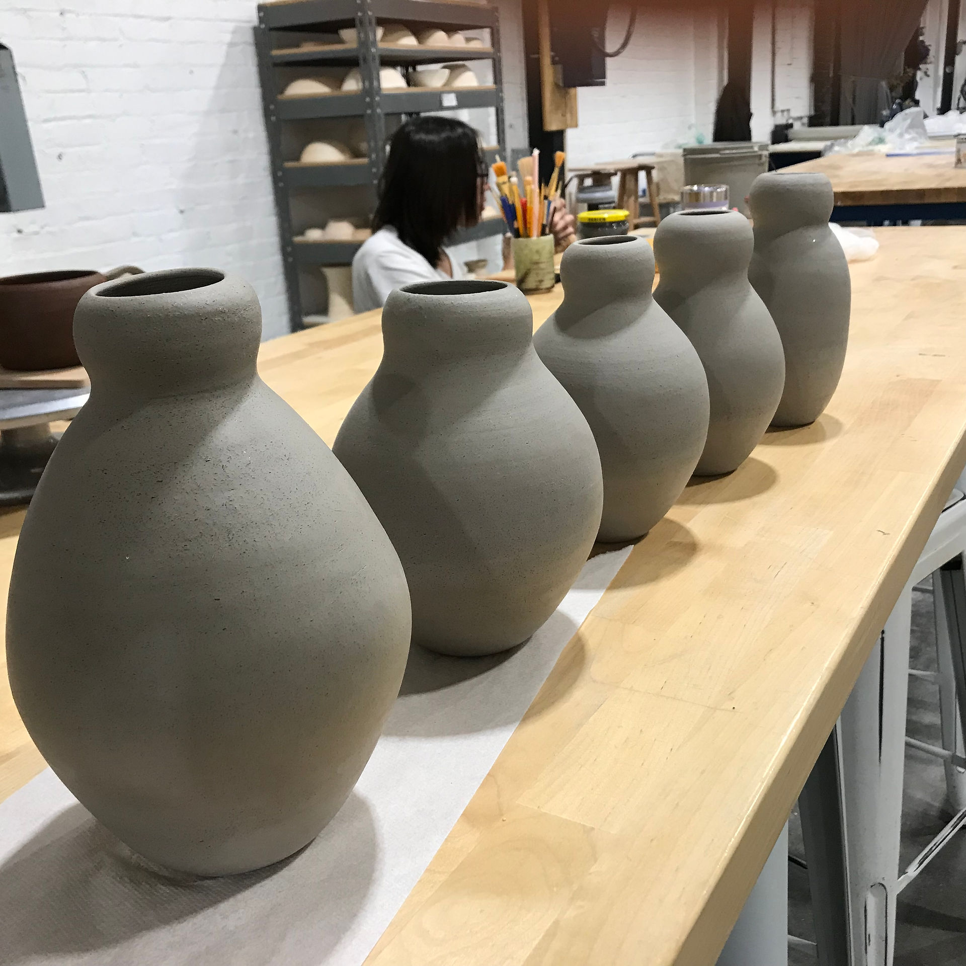 Five B-Mix vases in a line ready for bisque firing.