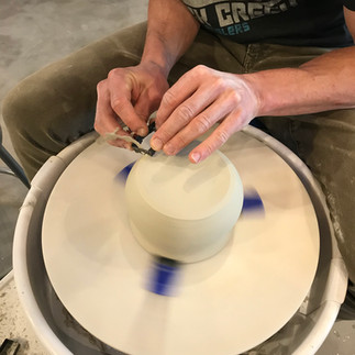 Trimming the foot of a pot on the wheel.