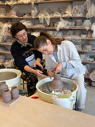 HanaKyle Moranz provides one-on-one instruction to a student during a body mechanics workshop at the pottery wheel.