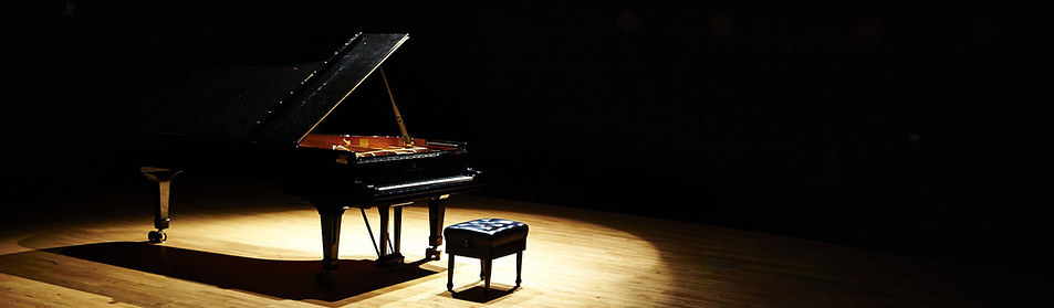 Spotlight piano on a darkened stage
