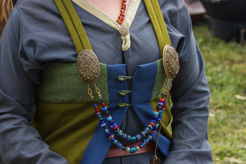Close up of richly decorated silver viking brooches with pearl necklace..jpg