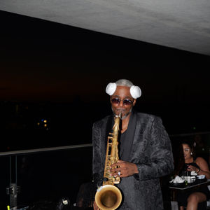 Musician performing live saxophone music under ambient lighting at KaLa Rooftop Lounge.