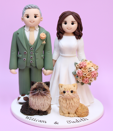 Personalised polymer clay wedding cake topper featuring a bride, groom in a sage green suit and two cats