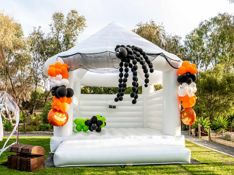 A spooky Halloween-themed inflatable castle, bright and cheerful, ready to entertain kids and add to the holiday spirit.