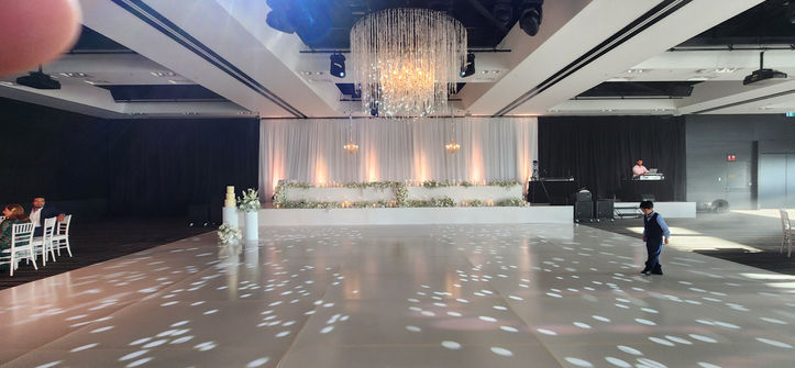 Guests dancing on white satin gloss dance floor at wedding reception