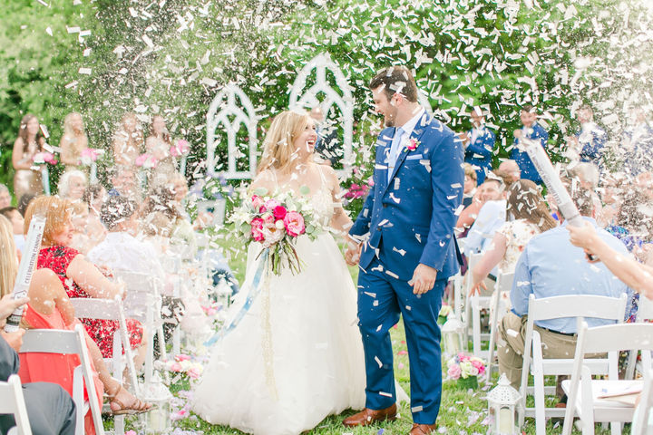 Bride and groom celebrate with confetti at garden wedding