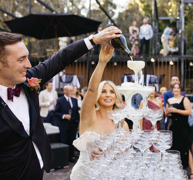Bride and groom celebrate with champagne tower during wedding toast