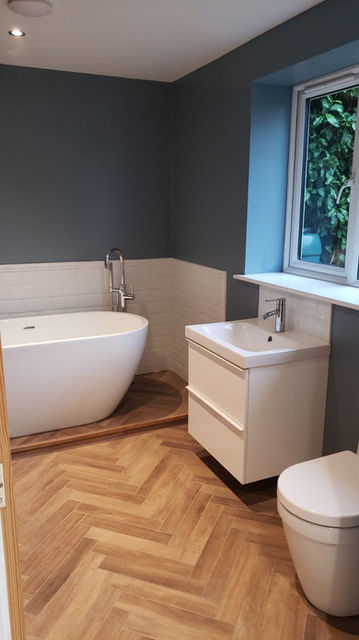 Free standing bathtub and herringbone floor tiles