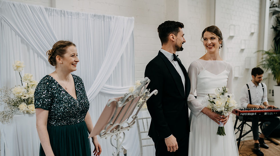 Lisa Schalles Freie Traurednerin von Ehrenworte lacht während der freien Trauung mit dem Brautpaar.