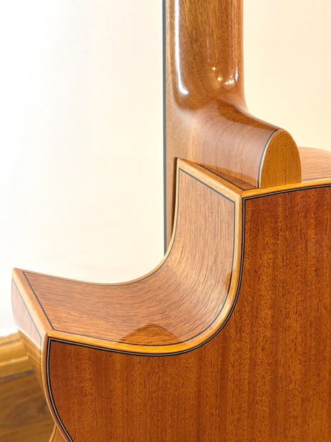 The rear of a Honduran Mahogany Cutaway with matching binding and thin purfling details.