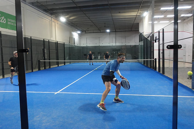 Padel player getting the ball off the wall.JPG