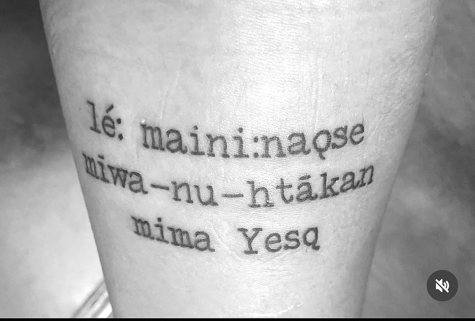 My tattoo features a phrase in Yesa:sahį, the language of the Eastern Siouan peoples, Indigenous to present-day North Carolina, South Carolina, Virginia, and Ohio, one of my ancestral tongues. It reads: "lé: maini:naǫse mīwa-nu-htākan mima Yesą", which translates to: "We are still here, we are Native, I am Yesah."