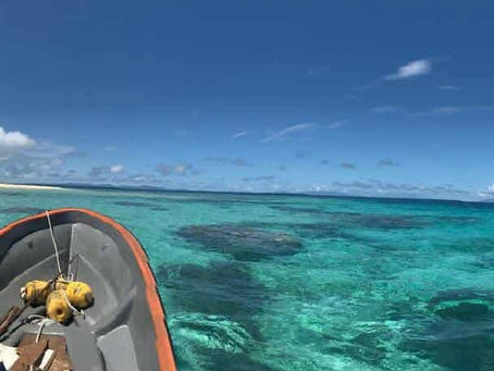 The front of the dinghy approaching crystal clear reefs. 