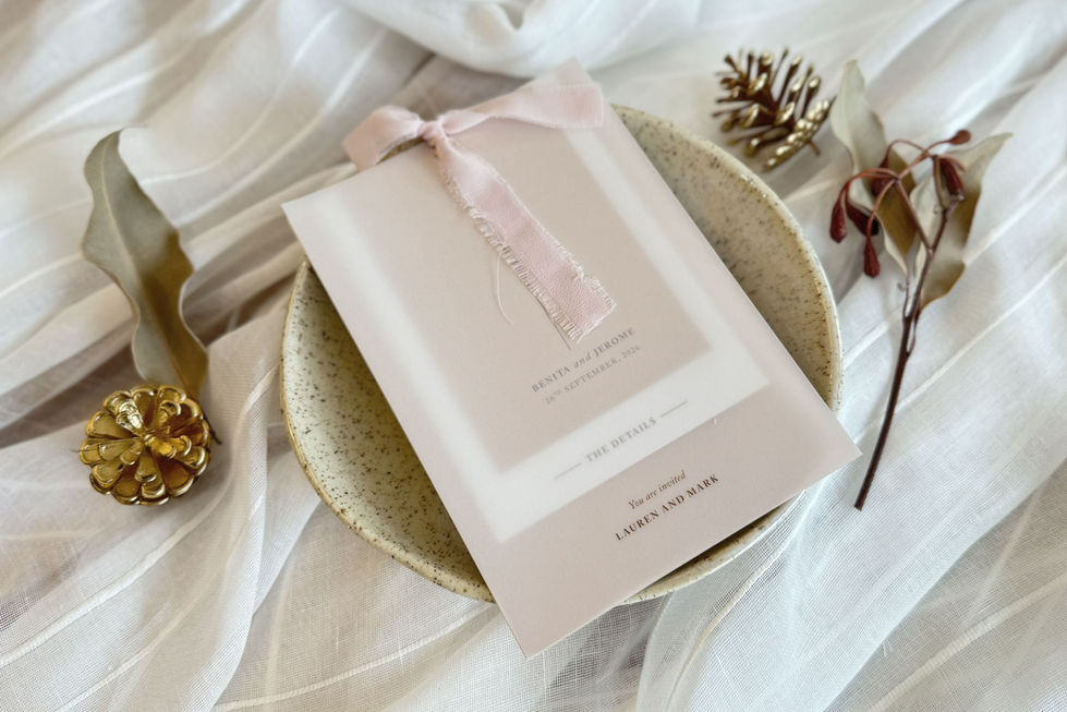Flatlay of modern wedding invitation with biscuit card, detail insert, and vellum wrap