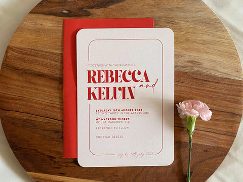 Simple red wedding invitation printed on blush pink cardstock with rounded corners