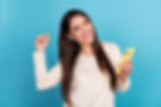 Woman wearing AirPods while holding an iPhone X in yellow casing