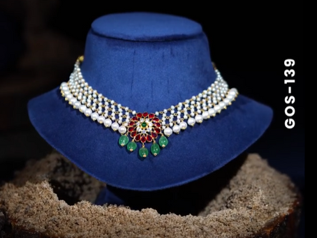 Adorn yourself with our mesh design gold and pearl choker set, centered with red and green Swarovski stones and emerald drops