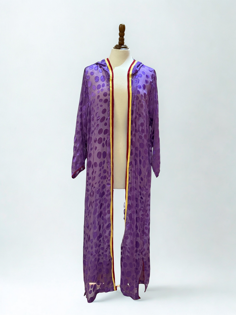 Robe violette à pois, avec capuche et bordures dorées sur mannequin, Alghorza création.