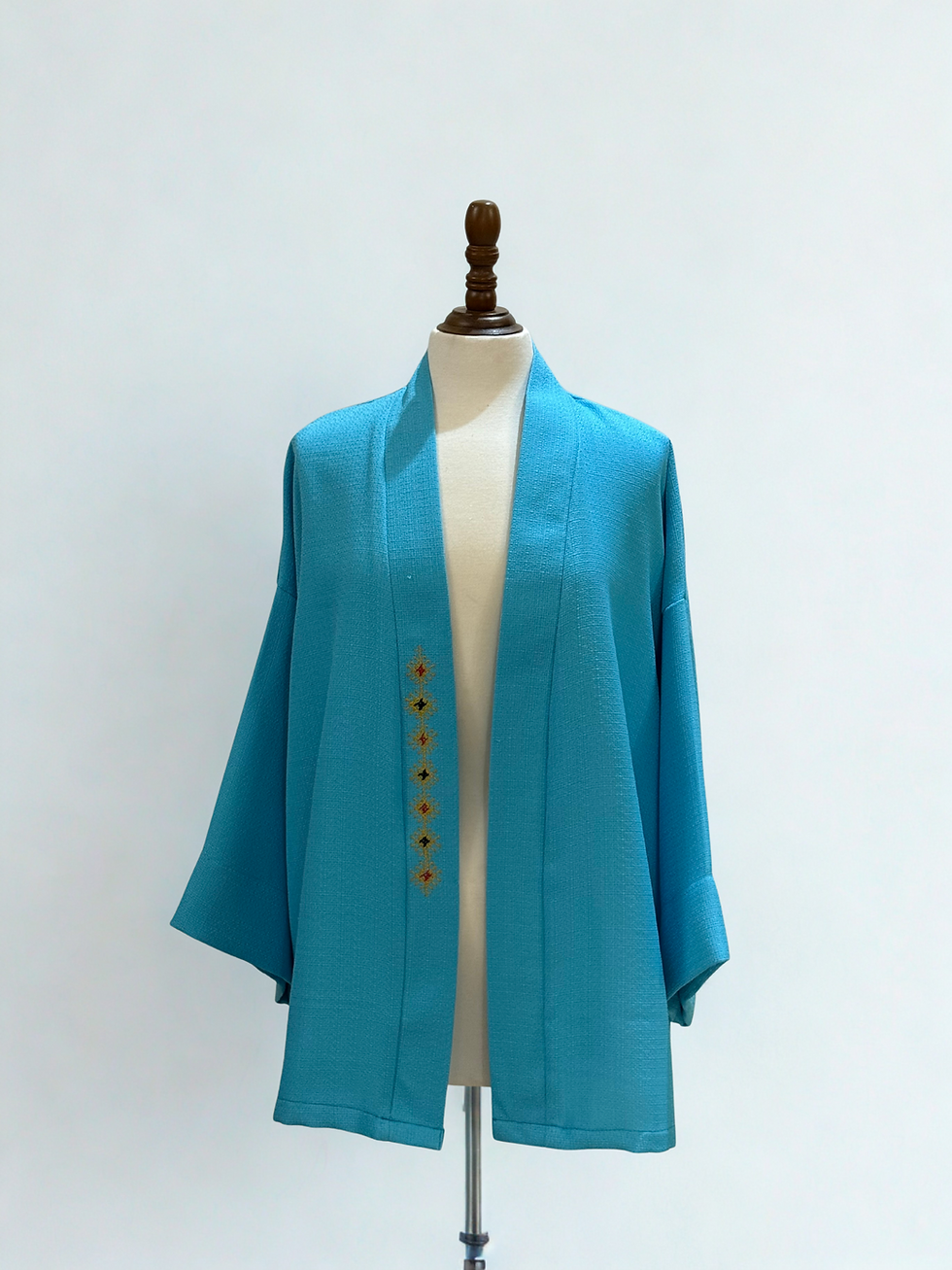 Veste bleue avec boutons dorés; Terre & Fils sur un mannequin sur fond blanc.