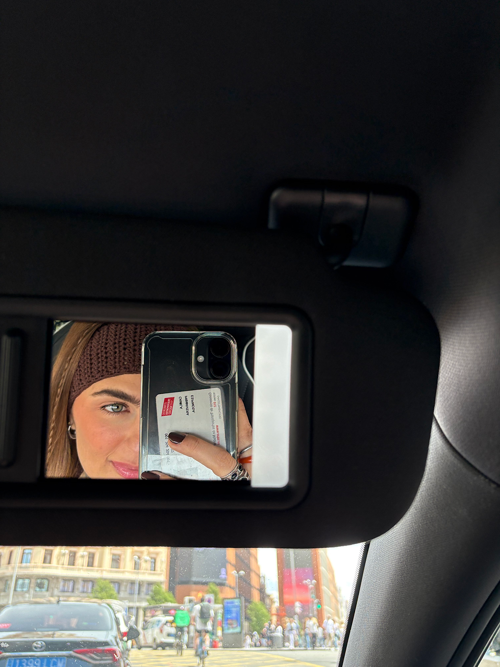 Modelo haciéndose un selfie en el espejo del coche luciendo la diadema de punto Rose Latte de THE NODO