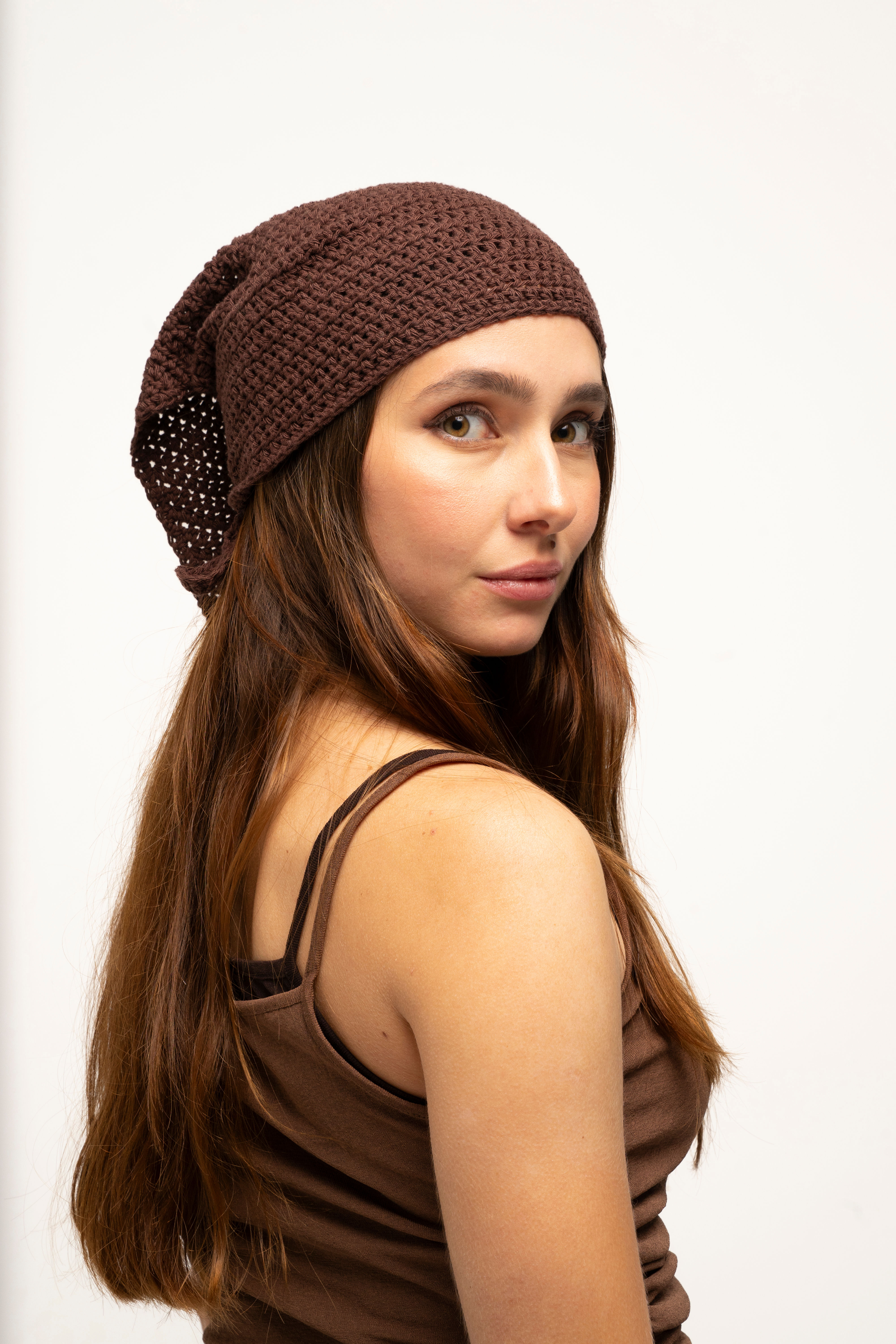 Primer plano lateral de la modelo posando en estudio con la bandana de punto Rose Latte