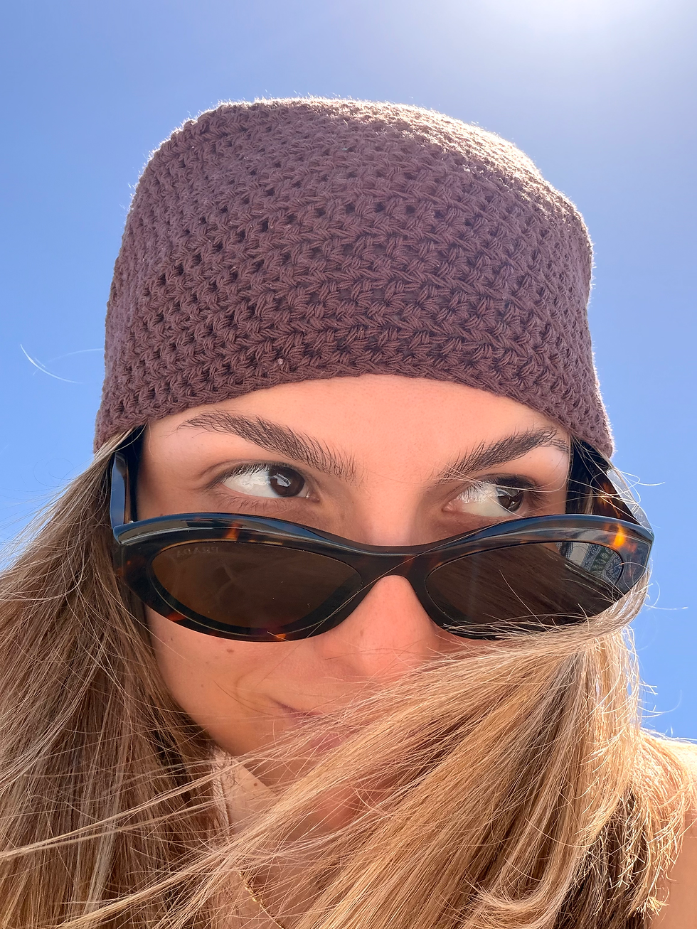 Primer plano de la modelo con gafas de sol luciendo la bandana de punto marrón de THE NODO