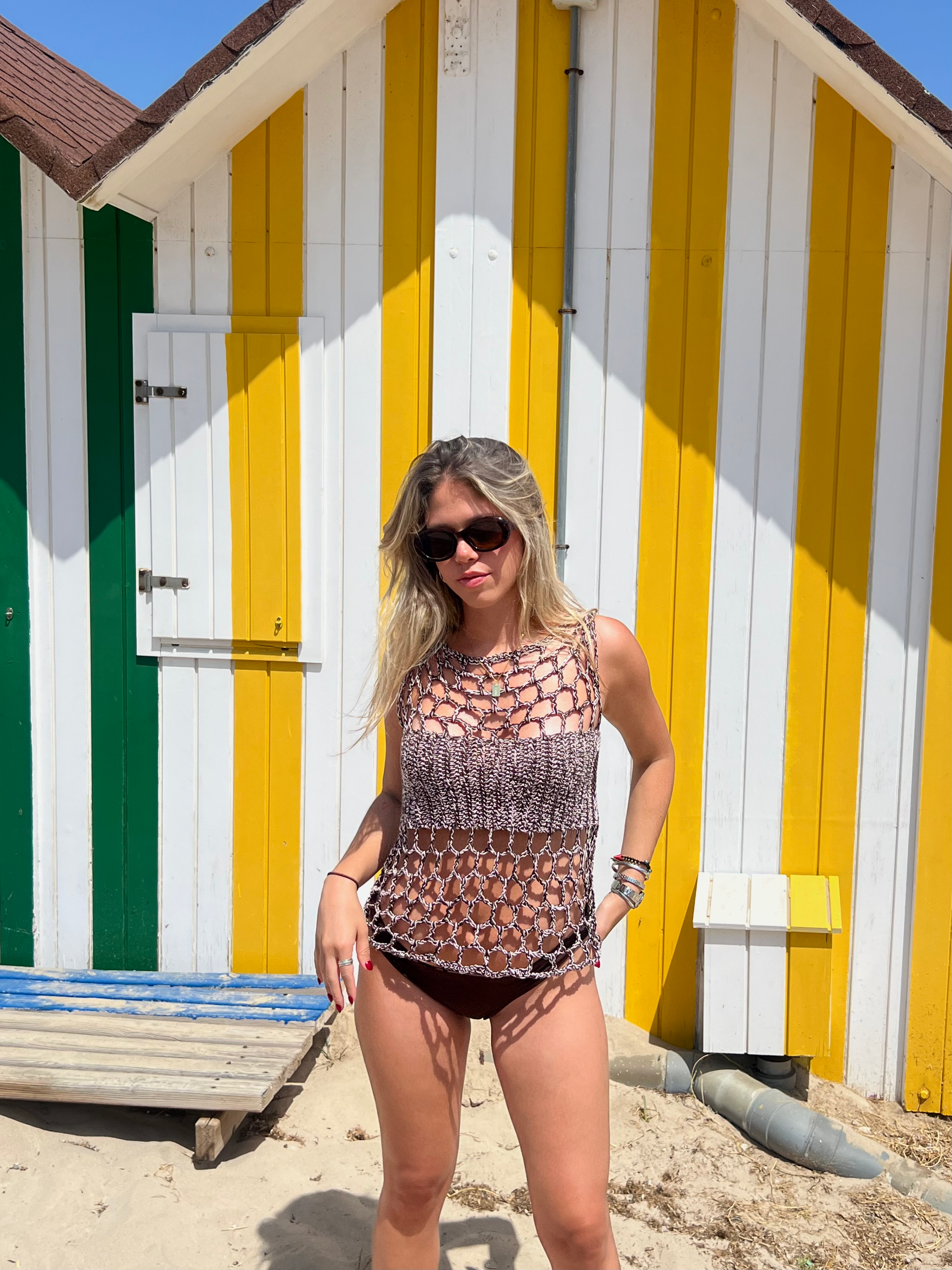 Modelo con gafas de sol y look veraniego del top halter de punto de THE NODO