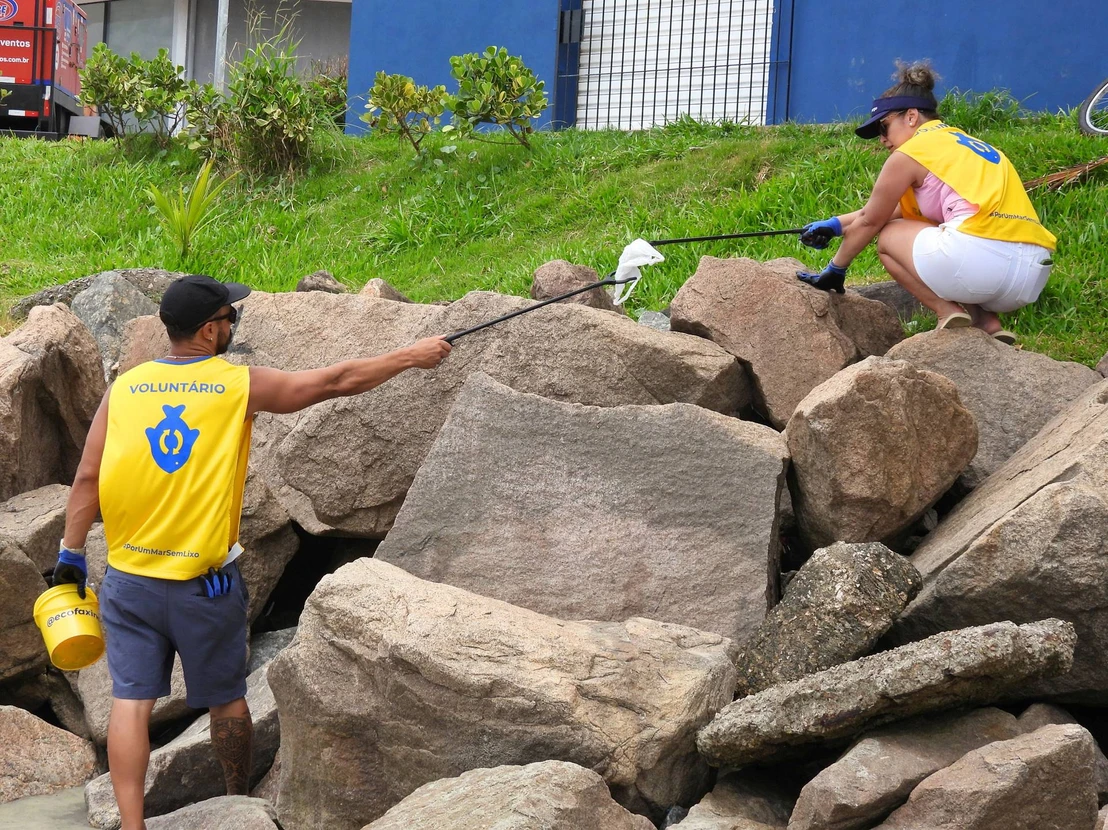 Voluntários retiram resíduos da Praia do José Menino, em Santos.