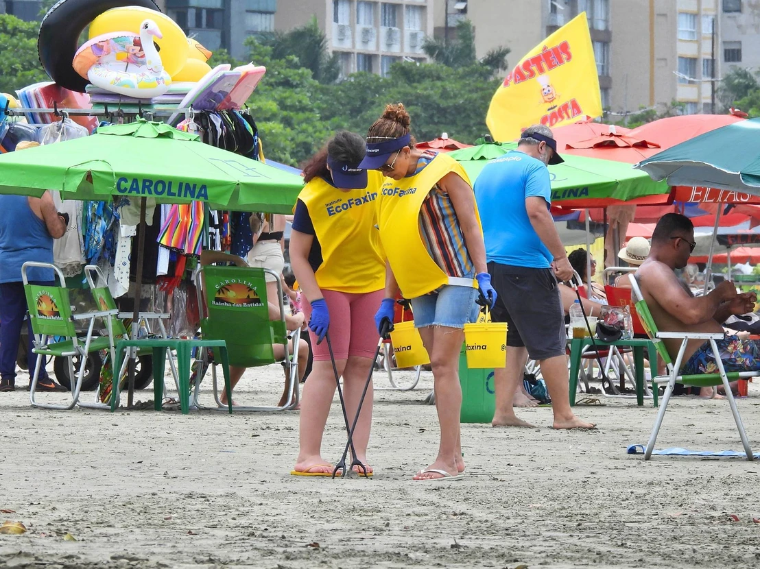 Mãe e filha retiram resíduos da Praia do José Menino, em Santos.