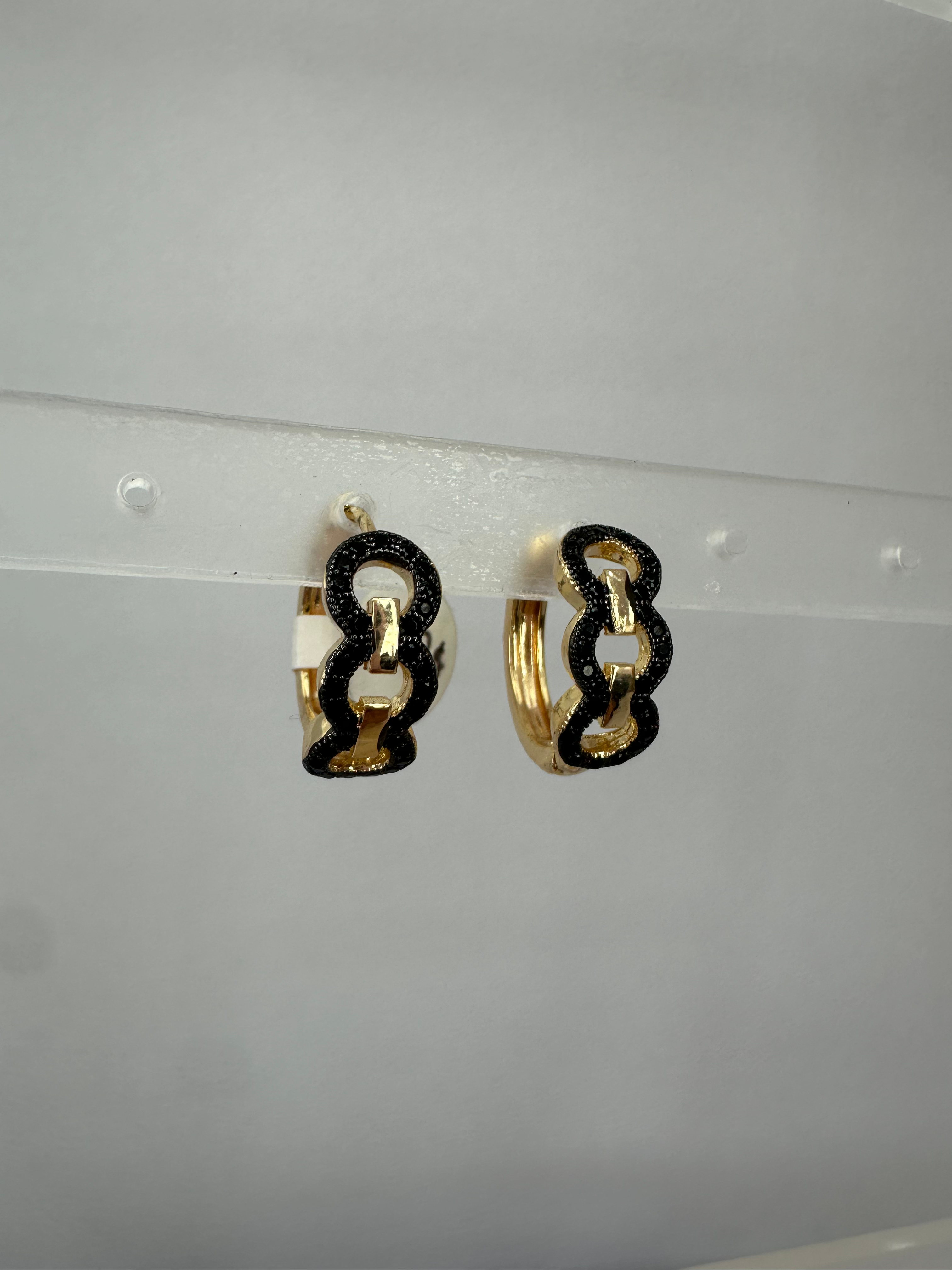 Arracadas pequeñas color dorado con círculos color negro