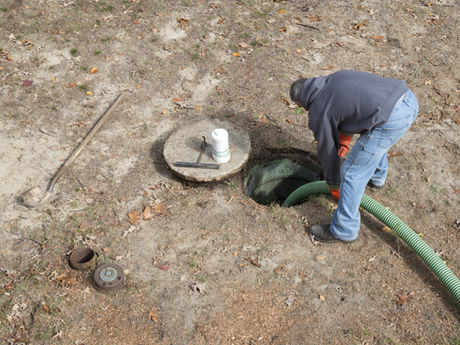 A male worker pumping a septic tank.