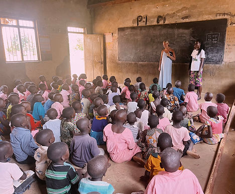 Children listening to a teacher in a classroom in rural Uganda
