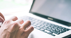 Closeup of hands tying on laptop keyboard