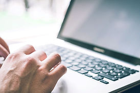 Image shows laptop, person typing a blog