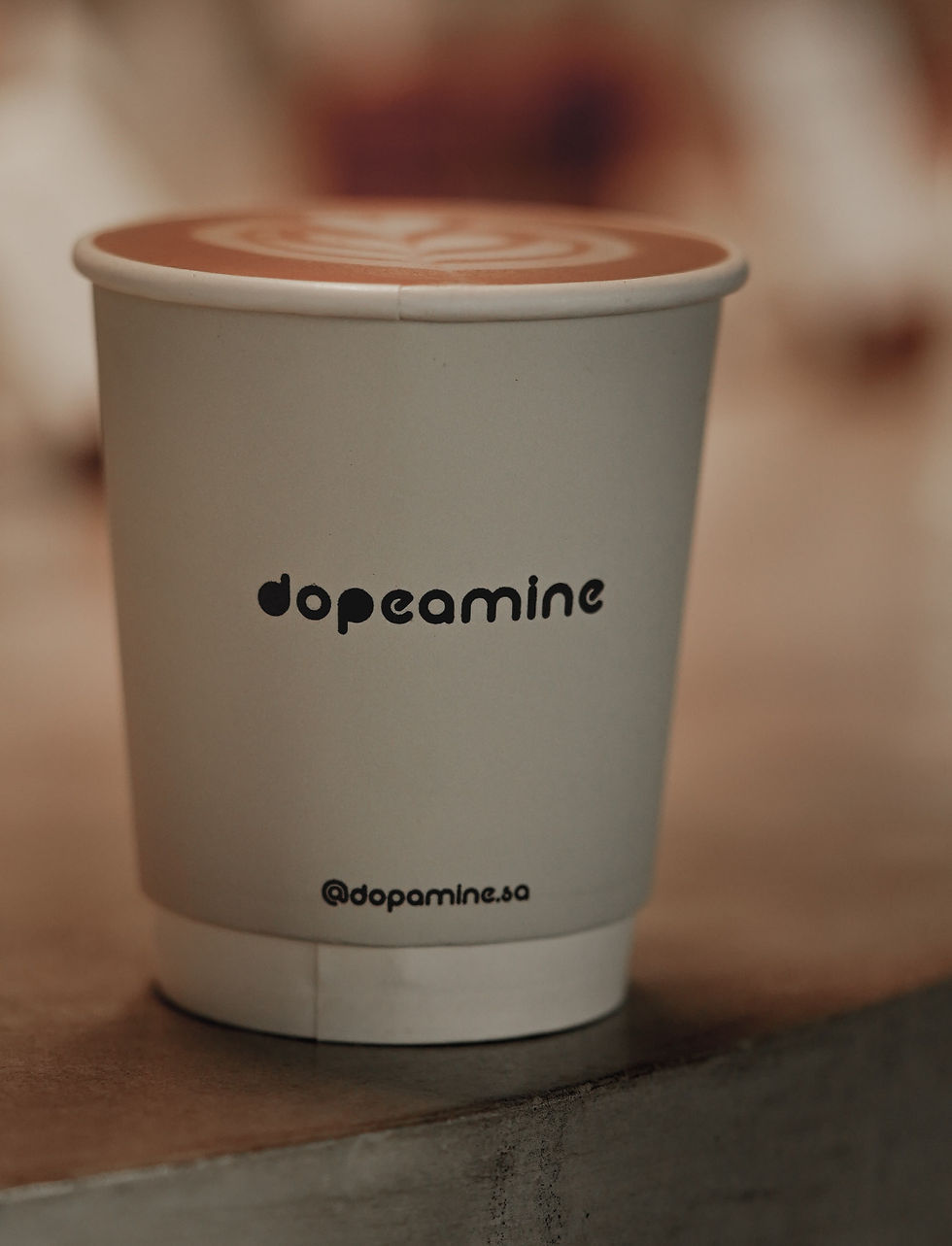 A latte coffee drink in a white cup labeled dopeamine. Mindfulness, Meditation, Best coffee, better focus.