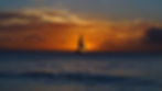 Sailboat on calm ocean at sunset, silhouetted against an orange and blue sky. Tranquil and serene atmosphere.