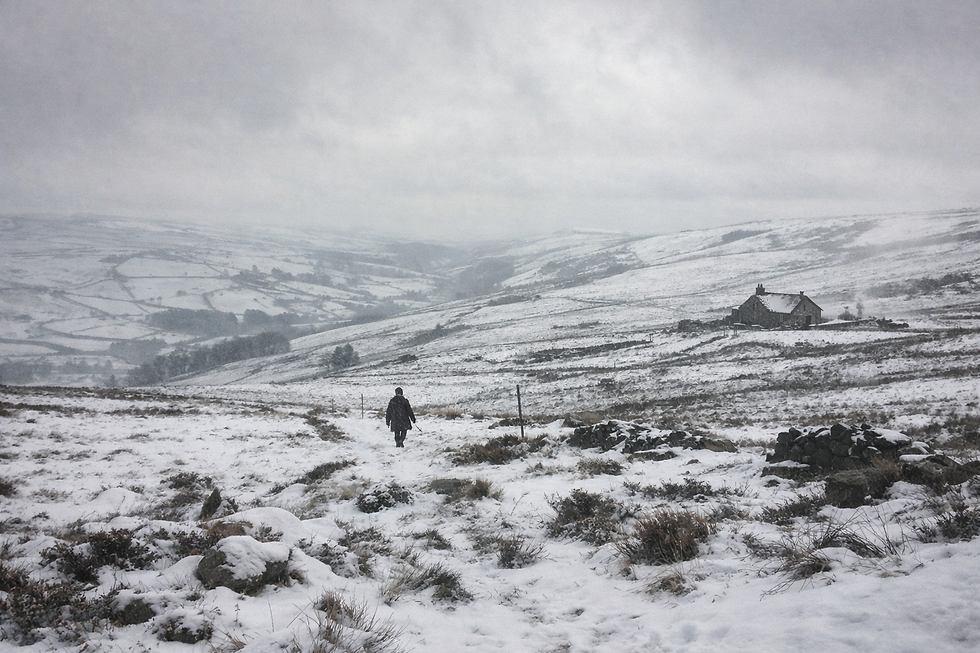 Snowy Yorkshire moorland with distant cottage.png