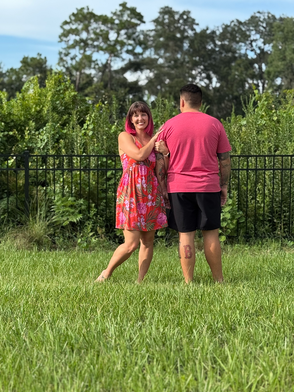 man and woman standing in grassy area linking arms