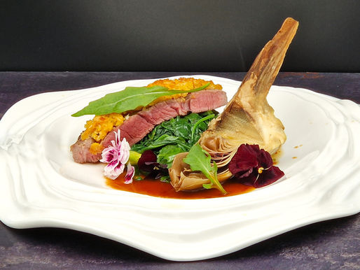 Lammsteaks mit Maiskruste, dazu angebratener Rucola und Artischocken