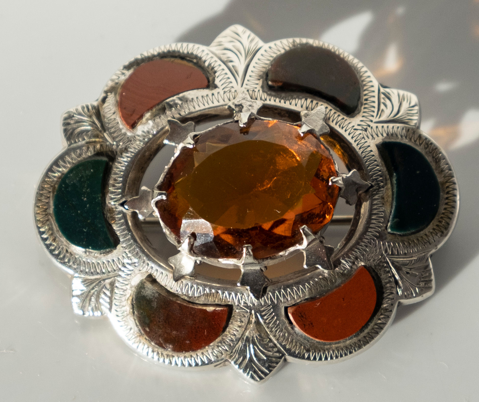 A late Victorian Scottish hardstone and cut citrine paste stone silver brooch