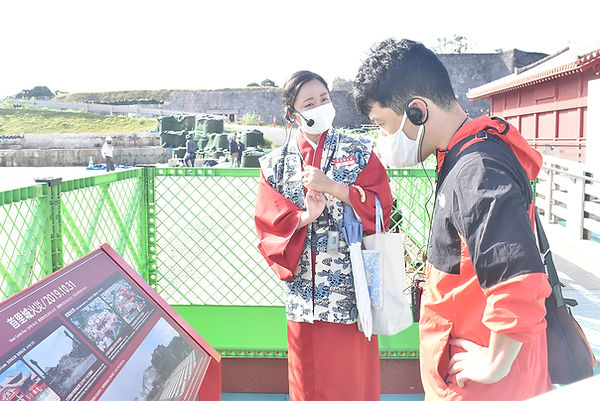 御庭で「ぐるっとツアー」の利用者に、火災の被害状況などの説明をする首里城公園のスタッフ(左)=16日、那覇市.jpeg