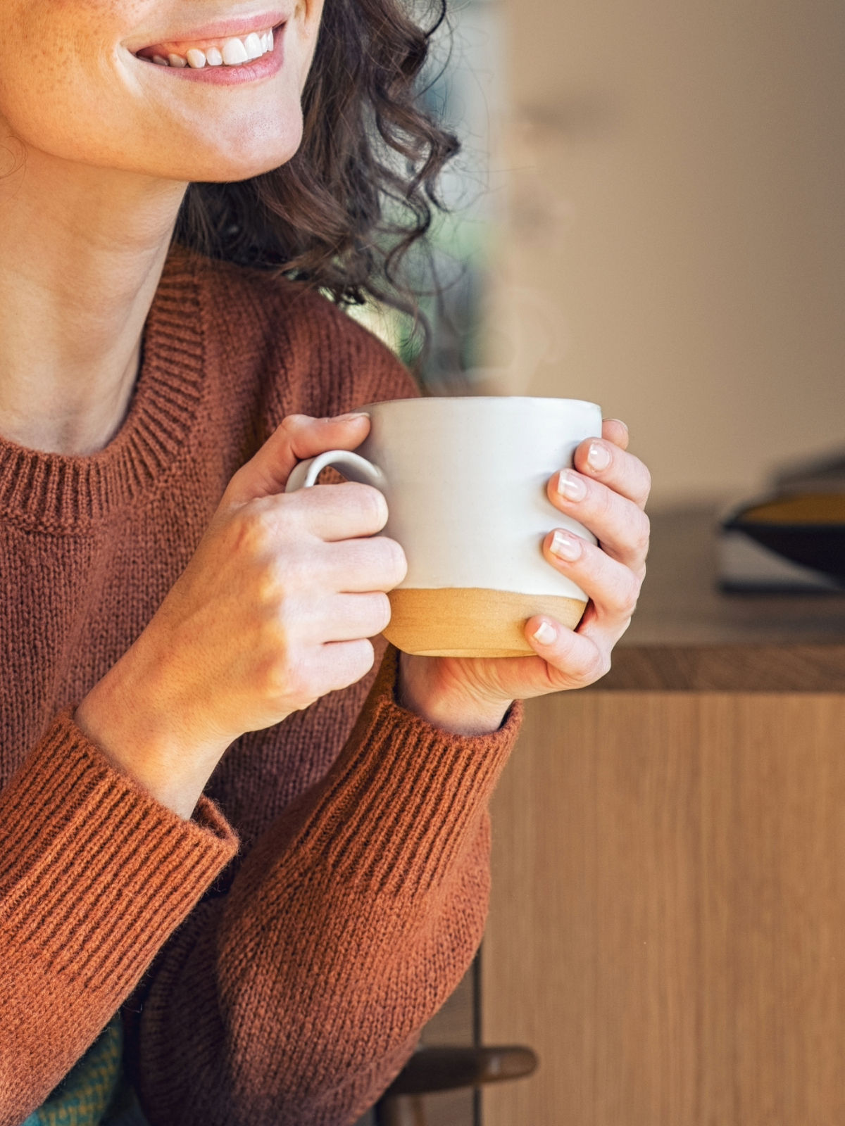 Frau hält Teetasse in der Hand mit Güfferschtee-Sirup