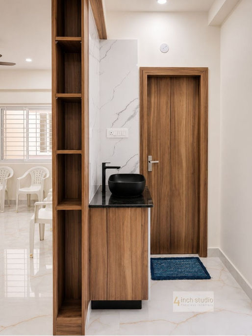 Side view of a wash basin unit with open shelving, wooden storage, and black vessel sink.