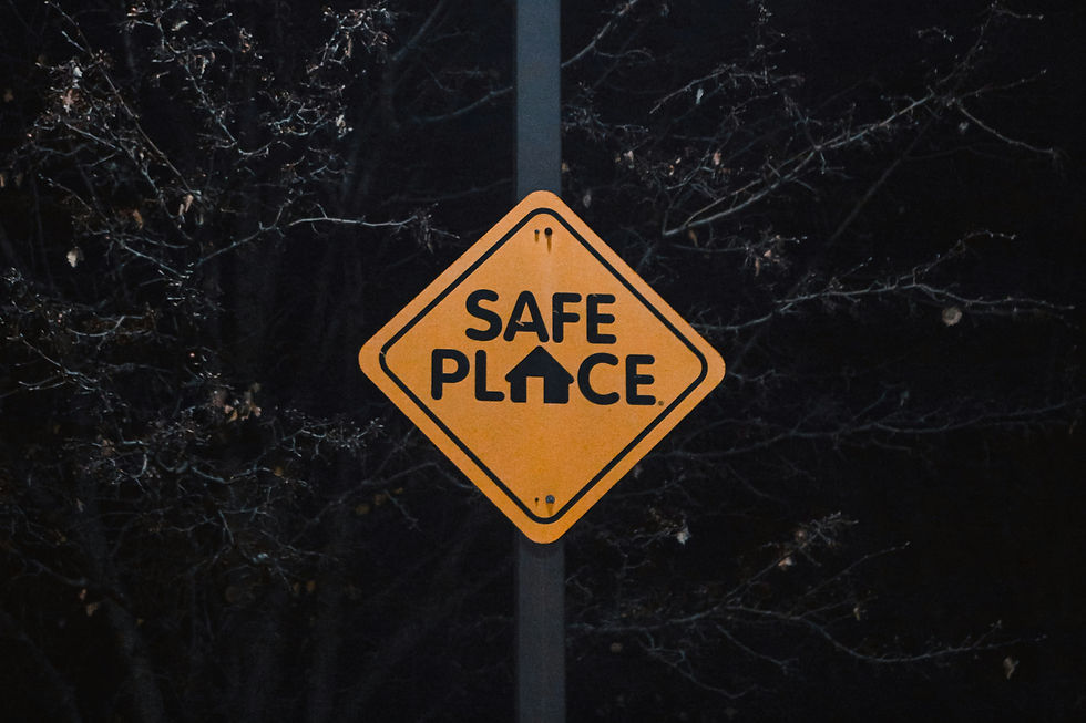 Yellow "Safe Place" sign on a pole at night, surrounded by dark, leafless branches, creating a serene yet mysterious mood.