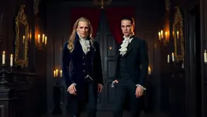 Lestat with blond hair and Louis with dark hair in an 18th-century gothic hallway with mirrors, red drapes, and candlelight – Reading Order – The Vampire Chronicles