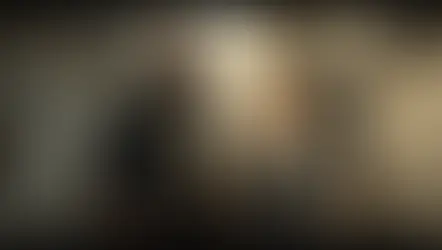 Cormoran Strike con abrigo oscuro y expresión cansada junto a Robin Ellacott con traje gris, rodeados de muros agrietados, barandillas oxidadas y bolsas caídas – resumen por capítulos del libro El oficio del mal