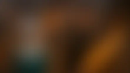 Louise con vestido verde y Reid con abrigo marrón, entre ruinas en llamas y un dragón sobrevolando con fuego – imagen del resumen por capítulos del libro Dioses y monstruos